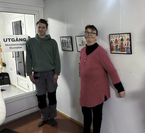 Foto föreställer man och kvinna vid vägg med målningar