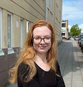 Porträtt av kvinna med glasöon och rödblont hår