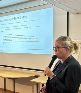 Bild visar kvinna i profil framför skärm på vägg