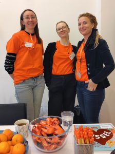 tre kvinnor i orangea kläder