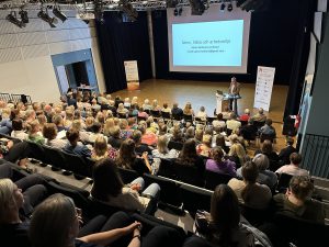 Foto av publik bakifrån i stor sal