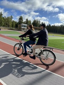 Foto visar två personer på en tandemcykel